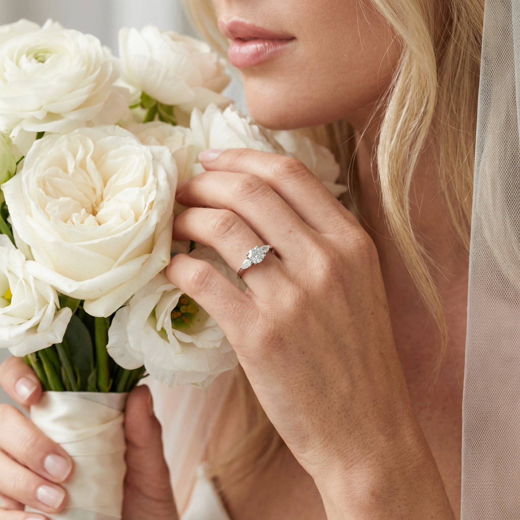 Bride with white bouquet wearing diamond engagement ring