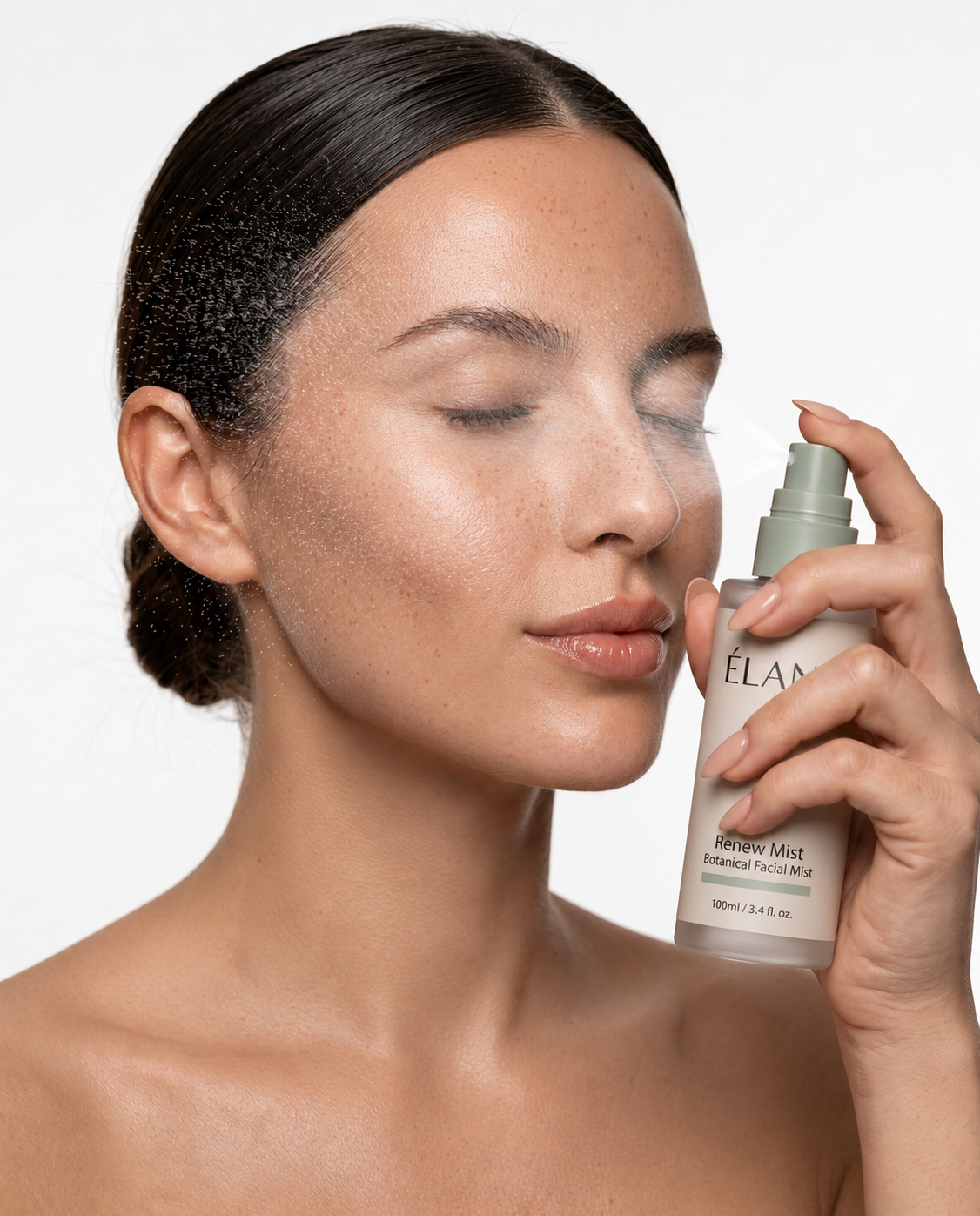 Model with eyes closed spraying ÉLANE Renew Mist botanical facial mist on her face